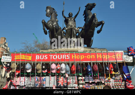 Un Souvenir des casquettes de baseball et des bâtons selfies sur Westminster Bridge avec la statue de la Reine Boadicée directement au-dessus. Banque D'Images