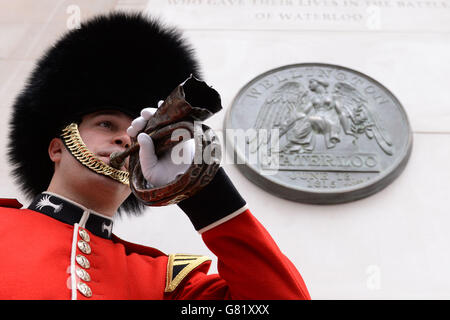 Le caporal Nick Walkley joue le dernier poste après le dévoilement d'un monument commémoratif en l'honneur des milliers de soldats qui ont combattu et sont morts à la bataille de Waterloo, à la gare de Waterloo, à Londres, pour souligner le 200e anniversaire de l'événement. Banque D'Images