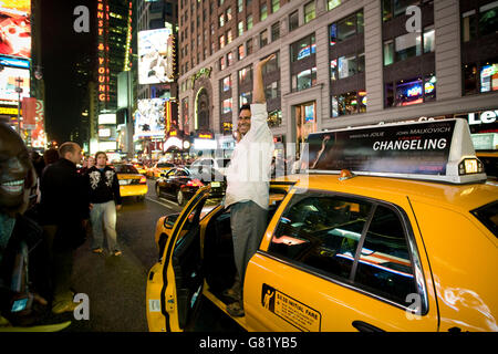 Un chauffeur de taxi célèbre comme il conduit par Times Square à New York, NY, United States, après l'annonce de Barack Obama Banque D'Images