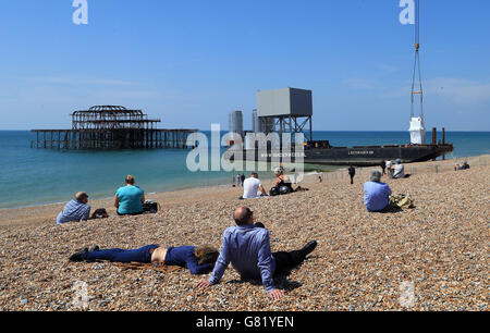 Les gens regardent comme des composants qui formeront le i360 à Brighton, dans l'est du Sussex, la première tour d'observation verticale de téléphérique au monde, sont déchargés sur Brighton Beach avant les travaux de construction. Banque D'Images