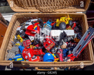 Une collection de jouets anciens de divers véhicules dans un panier dans un magasin d'antiquités Banque D'Images