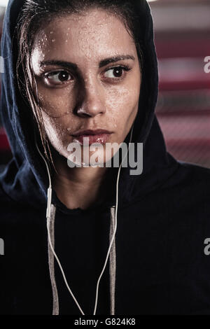 Close-up of épuisé woman listening music at gym Banque D'Images