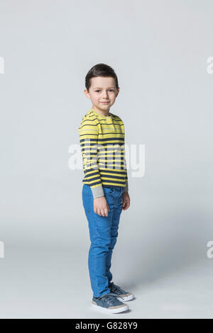 Portrait of smiling boy standing against white background Banque D'Images