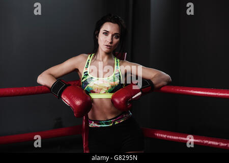 Portrait of female boxer se penchant au coin de ring de boxe Banque D'Images