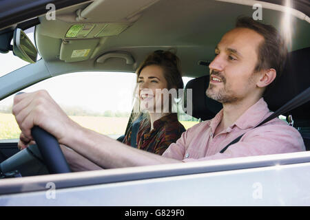 Heureux l'homme assis au volant en plus de woman in car Banque D'Images