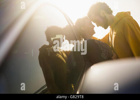 Vue latérale du couple leaning on car Banque D'Images