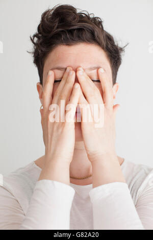Close-up of mid adult woman covering her face with hands Banque D'Images