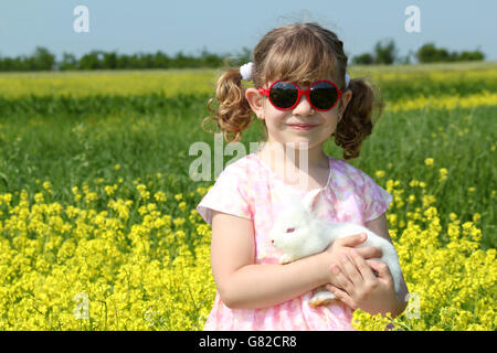 Little girl holding lapin nain blanc Banque D'Images