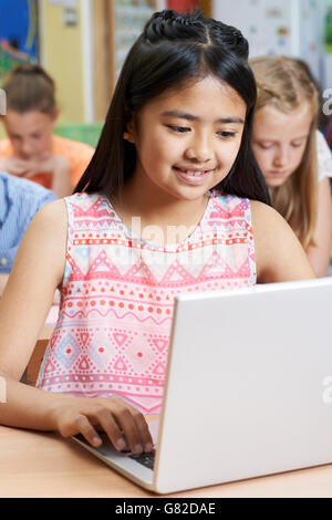 Élève de l'élémentaire femelle Using Laptop in Computer Class Banque D'Images