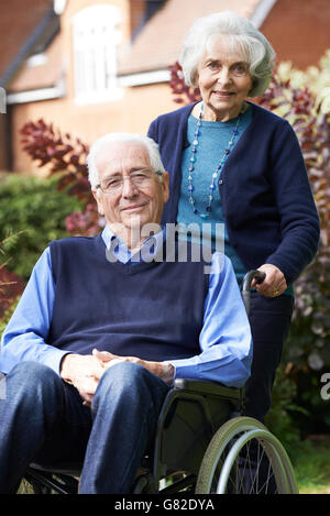 Senior Man In Wheelchair poussés par des femme Banque D'Images