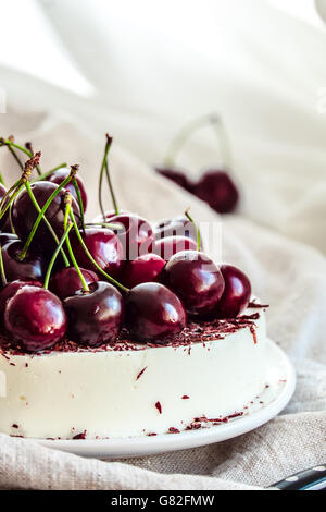 Gâteau mousse bavarois aux cerises et chocolat noir sur le dessus. Fait avec de la crème de fromage et de crème fouettée. Banque D'Images