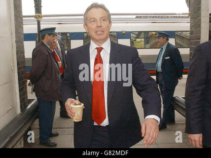 Tony Blair arrive à la station Wellingborough avec une tasse de café qu'il a achetée au buffet de la station. Banque D'Images