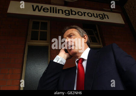 Le Premier ministre britannique Tony Blair sur son téléphone portable, en attendant un train à la gare de Wellingborough. Banque D'Images