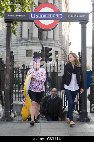 Des acteurs habillés de surfeurs se rendent dans le métro de Londres pour la campagne estivale de Teletext Holidays, pour marquer le début de la saison des fêtes d'été. Banque D'Images