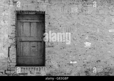 Porte en bois rustique en noir et blanc en arrière-plan - pierre aléatoire Banque D'Images
