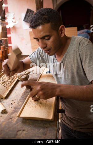 Un tanneur artisan travaille dans son atelier de la médina de Marrakech, Maroc. Banque D'Images