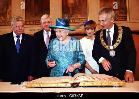 La reine Elizabeth II signe le Livre d'or à côté du maire de Francfort, Peter Feldmann, lors d'une visite à Romer, qui est l'hôtel de ville de Francfort depuis plus de six siècles, le deuxième jour complet d'une visite d'État de quatre jours en Allemagne. Banque D'Images