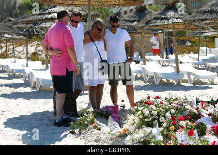 Les gens paient leur respect sur la plage près de l'hôtel RIU Imperial Marhaba à Sousse, en Tunisie, alors que les vacanciers britanniques défient les terroristes et continuent de rester à Sousse malgré le bain de sang sur la plage. APPUYEZ SUR ASSOCIATION photo. Date de la photo: Mardi 30 juin 2015. Les sables de Sousse étaient calmes et calmes aujourd'hui alors que les touristes et les habitants continuaient à rendre hommage aux 38 morts à l'extérieur des hôtels RIU Imperial Marhaba et Bellevue. Les fleurs continuent d'être posées à trois monuments commémoratifs en forme de cœur qui marquent les endroits où tant de personnes ont perdu la vie, avec beaucoup de gens en larmes lorsqu'ils lisent le Banque D'Images