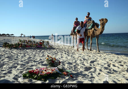 Les gens en chameaux passent des hommages sur la plage près de l'hôtel RIU Imperial Marhaba à Sousse, en Tunisie, alors que les vacanciers britanniques défient les terroristes et continuent de rester à Sousse malgré le bain de sang sur la plage. Banque D'Images