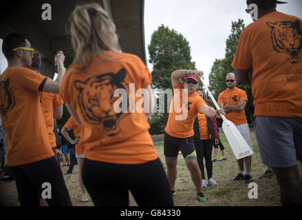 Les membres de l'équipage du Telstra rage se réchauffent lors du 20e festival de bateaux dragons de Londres à Hong Kong au Regatta Centre, Dockside Road, Londres. Banque D'Images