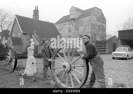 L'une des roues à cartels autrefois utilisées au moulin Bosmere du XVIIe siècle près du marché Needham, Suffolk, est en train d'être déplacée vers une nouvelle position pour servir de décoration.Sur la gauche se trouve le propriétaire du moulin, Jan Sniechowski, qui était lieutenant de l'armée polonaise pendant la guerre.Frank Pieniazek, compatriote et collègue de guerre, l'aide qu'il lui apporte. Banque D'Images