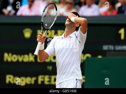 Novak Djokovic a l'air découragé lorsqu'il a pris un coup long contre Roger Federer lors de la finale des Mens Singles lors du treize jour des championnats de Wimbledon au All England Lawn tennis and Croquet Club, Wimbledon. Banque D'Images