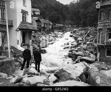 La police se trouve sur les restes d'un pont à Lynmouth, dans le Devon, qui a été dévasté par les inondations. Banque D'Images