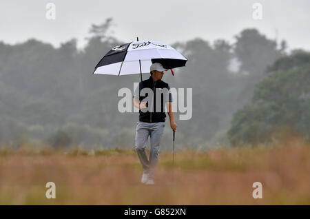 Le Jordan Spieth des États-Unis se protège de la pluie le 5 lors d'une journée d'entraînement avant l'Open Championship 2015 à St Andrews, Fife. Banque D'Images