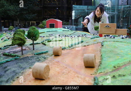 L'artiste culinaire Michelle Wibowo apporte la touche finale au gâteau carré Kerrygold de 10 mètres à la place de Finsbury Avenue à Londres. Banque D'Images