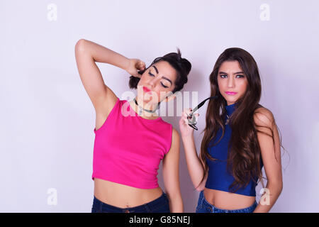 Portrait de deux belles femmes qui posent. Concept d'amitié. Amis mode et élégant, plus isolé sur fond gris. Banque D'Images