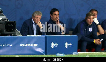 England manager Roy Hodgson (à gauche) et l'entraîneur Gary Neville (centre) s'asseoir abattus sur le banc pendant la série de 16 match au stade de Nice, Nice, France. Banque D'Images