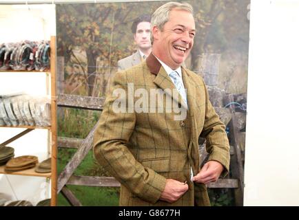 Nigel Farage, le dirigeant de l'UKIP, essaie de porter une veste alors qu'il visite le salon CLA (Country Landowers Association) à Harewood House, près de Leeds, West Yorkshire. Banque D'Images