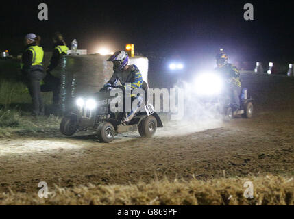 Les pilotes sur leurs tondeuses à gazon qui entrent dans la nuit, lors de la course de tondeuse à gazon BLMRA de 12 heures, qui s'est tenue à Five Oaks, près de Billingshurst dans West Sussex. Banque D'Images