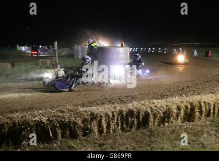 Les pilotes sur leurs tondeuses à gazon qui entrent dans la nuit, lors de la course de tondeuse à gazon BLMRA de 12 heures, qui s'est tenue à Five Oaks, près de Billingshurst dans West Sussex. Banque D'Images