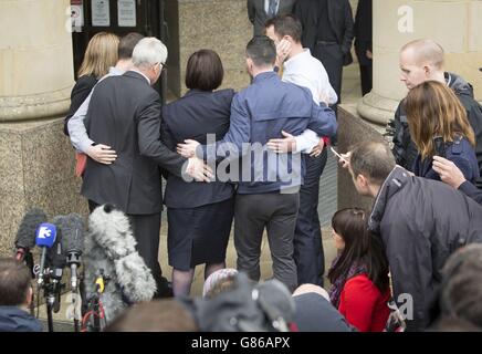 John Buckley embrasse sa femme Marian Buckley avec leurs trois fils après avoir fait une déclaration devant la haute cour de Glasgow après qu'Alexander Pacteau ait admis avoir battu leur fille Karen à mort avec une clé, puis avoir essayé de se débarrasser de son corps à l'aide de soude caustique. Banque D'Images