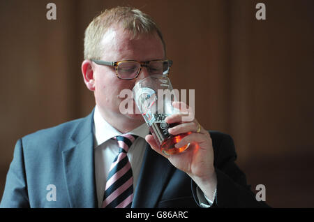 Pubs le ministre Marcus Jones (à gauche) participe au processus de jugement lors du Great British Beer Festival annuel organisé par la campagne pour Real Ale (CAMRA) à Olympia à Londres. Banque D'Images