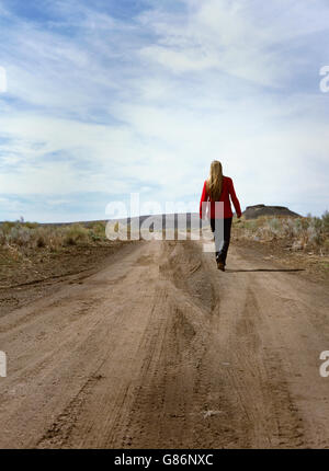 Une femme marchant dans un chemin de terre. Banque D'Images