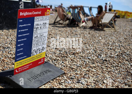 Un panneau d'information pour les amateurs de plage sur la plage de Brighton, dans l'est du Sussex, tandis que les membres du public apprécient le temps chaud. Banque D'Images