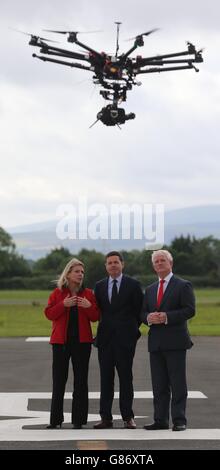 Le capitaine Julie Garland avec le ministre des Transports, du Tourisme et des Sports Paschal Donoghue, (au centre), et le directeur de la réglementation de la sécurité de l'Autorité irlandaise de l'aviation (IAA) Ralph James, sous un drone de type Octocopter à la première UAAI (Unhabitée Aircraft Association of Ireland), rencontrent l'événement de présentation des drones à l'aéroport Weston de Lucan Co Dublin. Banque D'Images