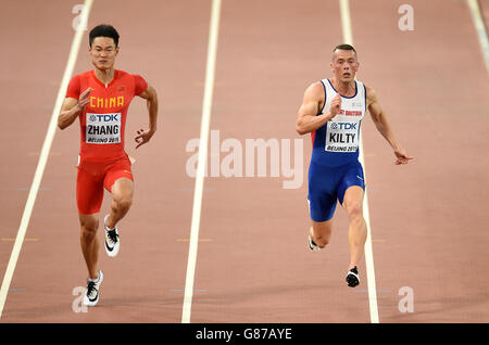 Peimeng Zhang (à gauche) en Chine et Richard Kilty en Grande-Bretagne pendant les 100 mètres des hommes s'échauffe lors des championnats du monde de l'IAAF au stade national de Beijing, en Chine. Banque D'Images