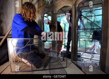 Les restaurateurs de Holy Well Glass placent le verre au plomb dans les arches de fenêtres après avoir enlevé une fenêtre en vitrail dans la chapelle de la Vyne, une propriété du National Trust à Sherborne St John, Hampshire. Banque D'Images