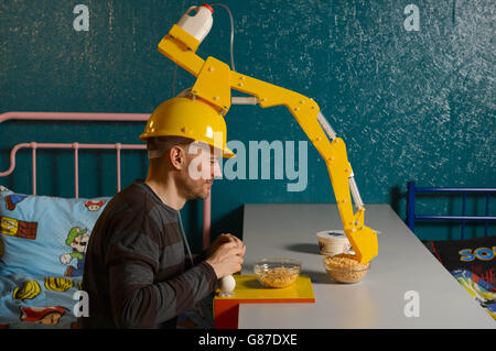 L'artiste et inventeur Dominic Wilcox présente son dernier gadget, le « Crane Head Cereal Serving Device », de la collection Wearable Brek de Kellogg, au Cereal Killer Cafe de Camden, Londres. Banque D'Images