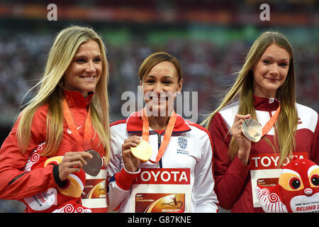 Jessica Ennis-Hill, en Grande-Bretagne, célèbre avec sa médaille d'or sur le podium lors de la cérémonie de présentation du Women's Heptathlon, aux côtés de la médaillée d'argent Brianne Theisen-Eaton du Canada (à gauche) et de la médaillée de bronze Laura Ikauniece-Admidina (à droite) de Lettonie, le troisième jour des Championnats du monde de l'IAAF au Stade national de Beijing, en Chine. Banque D'Images