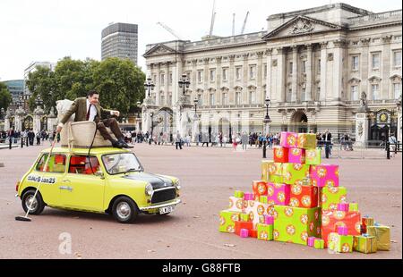 M. Bean, joué par Rowan Atkinson, célèbre le 25e anniversaire du personnage sur le Mall en face de Buckingham Palace, Londres, sur sa marque Mini. Banque D'Images
