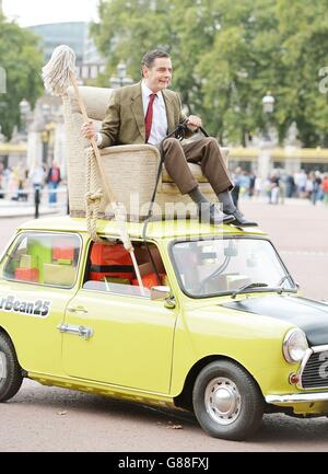 M. Bean, joué par Rowan Atkinson, célèbre le 25e anniversaire du personnage sur le Mall en face de Buckingham Palace, Londres, sur sa marque Mini. Banque D'Images