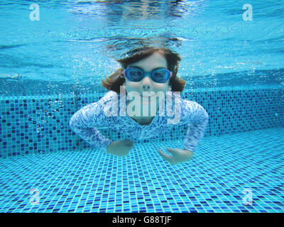 Girl swimming underwater in swimming pool