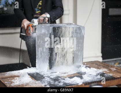 Jens Thom Ivarsson coupe un bloc de glace à l'extérieur de l'ICEBAR à Londres, qui a été redessiné par le sculpteur et dispose d'une sculpture de crâne de glace de 6 pieds de haut, un kit de tambour de glace sur pied, Un bar décoré de clous de glace punk Rock et d'un trône de Rock sculpté à l'aide de leur 10ème anniversaire de thème ICEBAR LONDON ROCKS. Banque D'Images