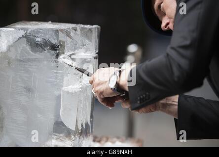 Jens Thom Ivarsson coupe un bloc de glace à l'extérieur de l'ICEBAR à Londres, qui a été redessiné par le sculpteur et dispose d'une sculpture de crâne de glace de 6 pieds de haut, un kit de tambour de glace sur pied, Un bar décoré de clous de glace punk Rock et d'un trône de Rock sculpté à l'aide de leur 10ème anniversaire de thème ICEBAR LONDON ROCKS. Banque D'Images