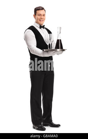 Portrait d'un jeune homme garçon portant un plateau avec deux verres de vin rouge et isolé sur fond blanc Banque D'Images