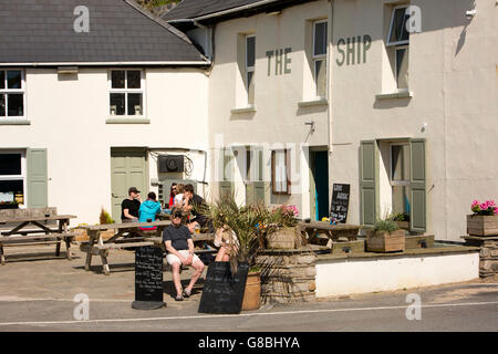 Royaume-uni, Pays de Galles, Ceredigion, Llangrannog, Village, les clients assis au soleil à l'extérieur de l'auberge Banque D'Images